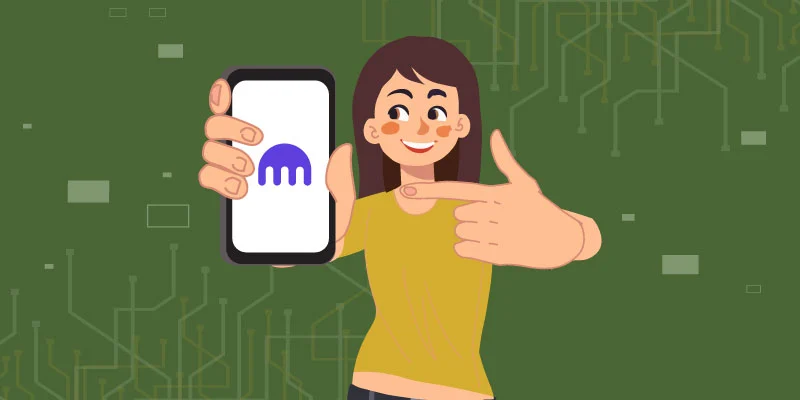 A smiling woman holding a smartphone displaying the Kraken logo, pointing to the screen, symbolizing easy access to Kraken's platform from anywhere.
